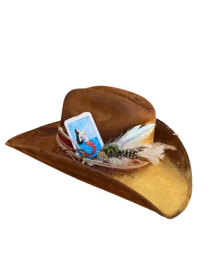 Sombrero estilo texano de gamuza con aplicaciones de carta de la lotería, plumas y tiras de gamuza.